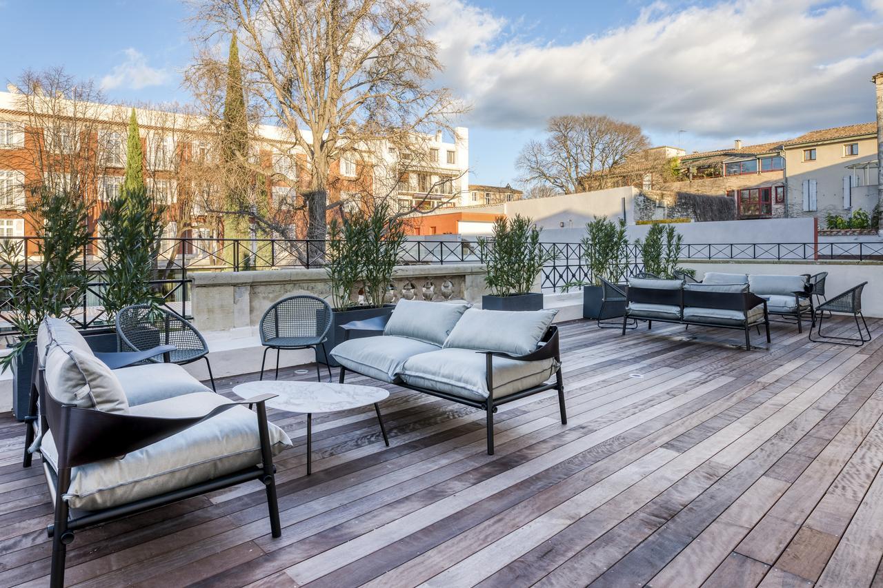 Salons de jardin et plantes en pots sur une grande terrasse en bois