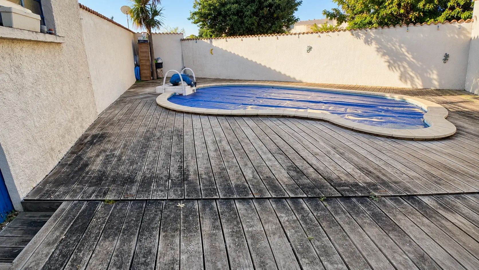 Terrasse en bois autour de la piscine avant intervention